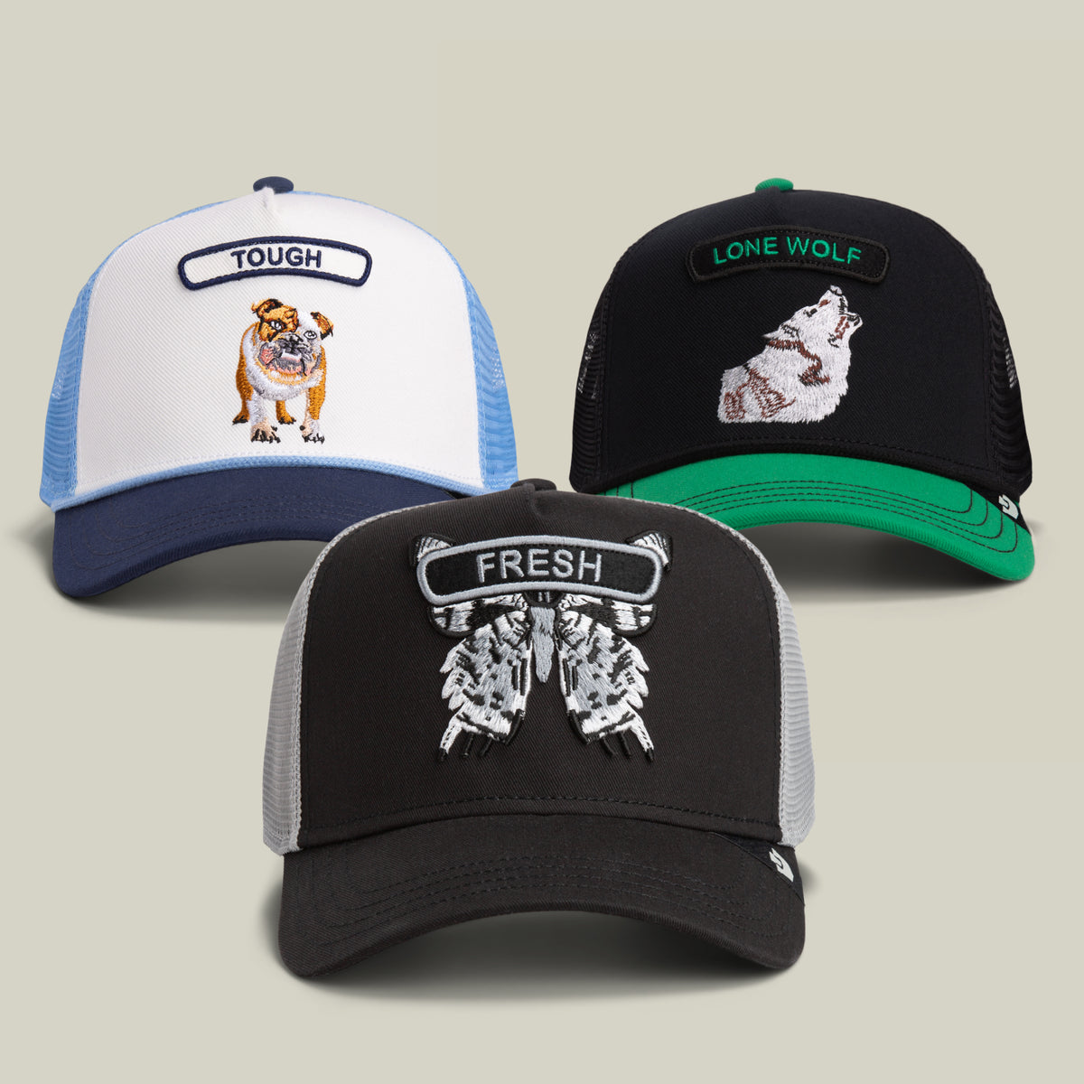 The Rock n Roll is Dead Bundle from Goorin Bros. includes three trucker hats: one featuring a bulldog with the word TOUGH, another with a wolf and LONE WOLF, and a third showcasing a pair of sneakers with FRESH. Each hat has a mesh back and embroidered patch.