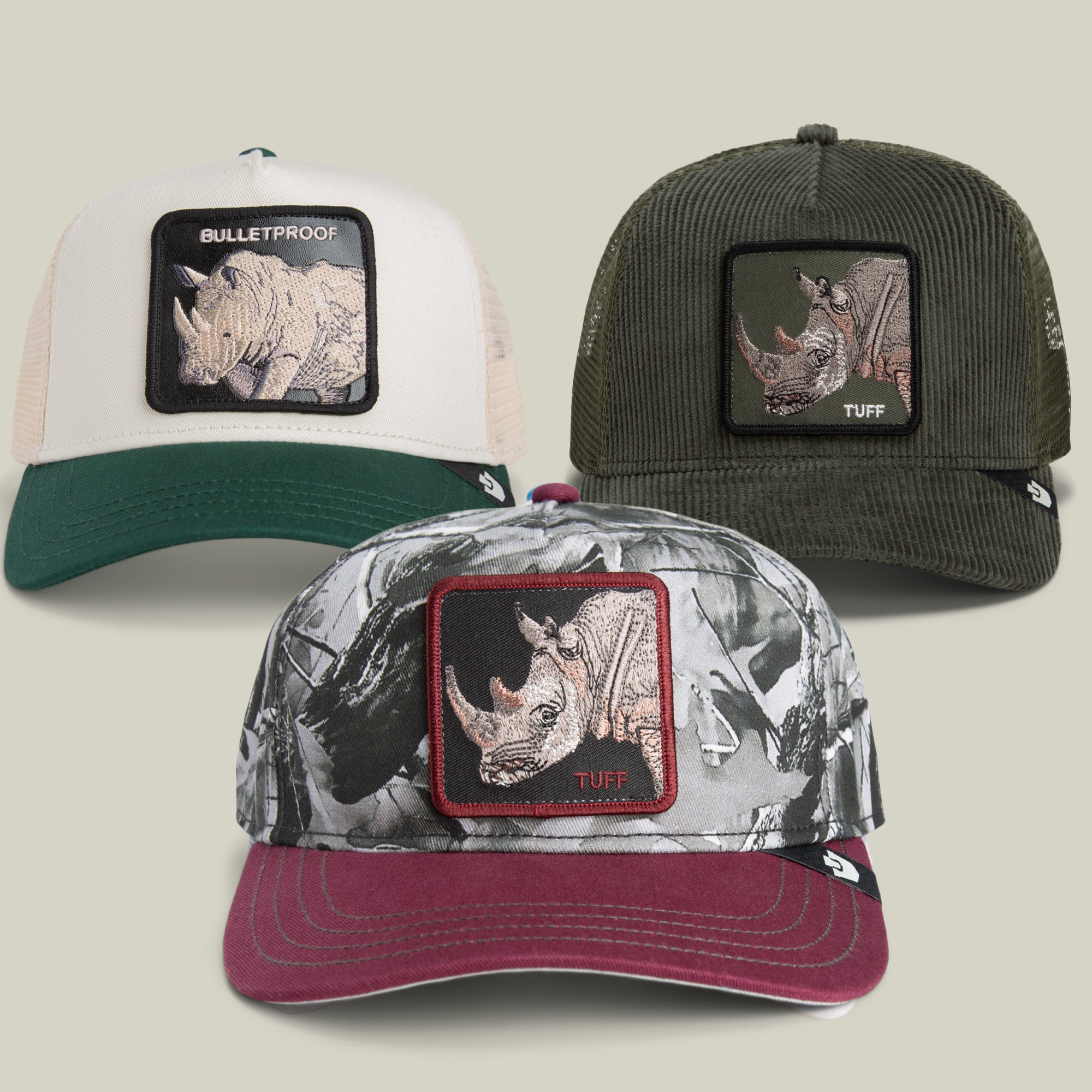 Introducing the Absolute Unit Bundle by Goorin Bros.—a trio of standout baseball caps, each displaying a bold rhino patch and distinctive design: a crisp white and green, a classic green corduroy, and a rugged camouflage with a burgundy brim. Embellished with BULLETPROOF or TUFF patches, these caps inspire you to Stand Tuff and Stand Strong in style.