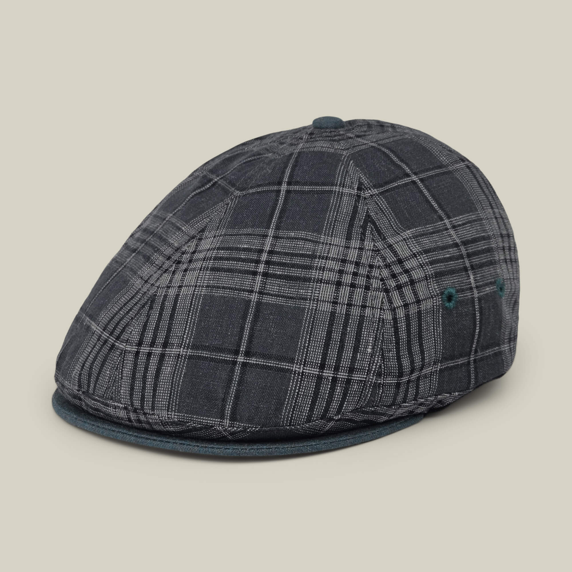 The Point Lobos by Goorin Bros. is a gray plaid 6-panel Ivy flat cap featuring a curved brim, side ventilation eyelets, and a textured pattern. Expertly handmade in the USA from a breathable cotton blend, it is pictured against a plain light background.