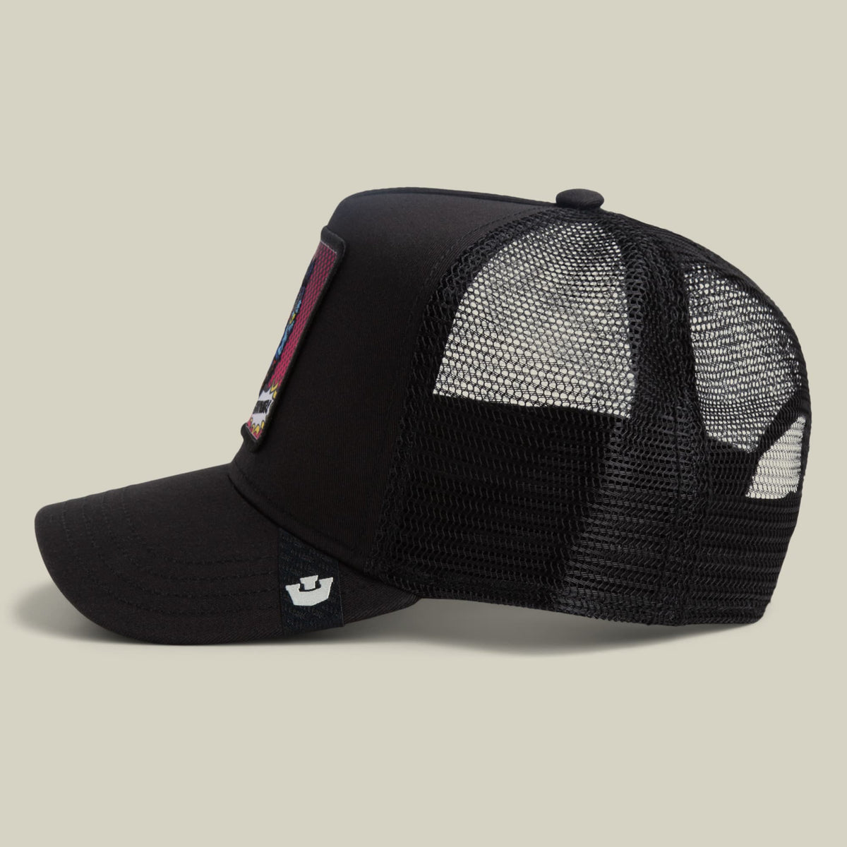 The Goorin Bros. POPArt - Panther trucker hat features a black canvas front with a mesh back panel, pink side patch detail, and small logo emblem, shown in a studio product shot from the side.