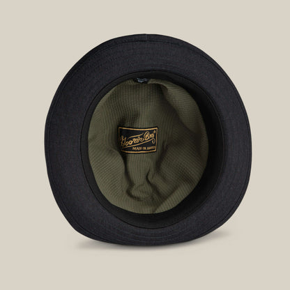 The Goorin Bros. Big Stepper is a black bucket hat seen from above, featuring an olive green inner lining and a "Made in America" label—making it a stylish accessory for any outfit.