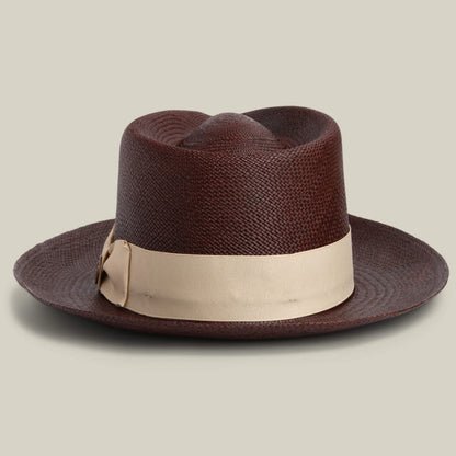 The Goorin Bros. John Sr. is a brown textured toquilla teardrop fedora with a wide brim, beige ribbon band, and 50 UPF sun protection, shown against a plain light background.