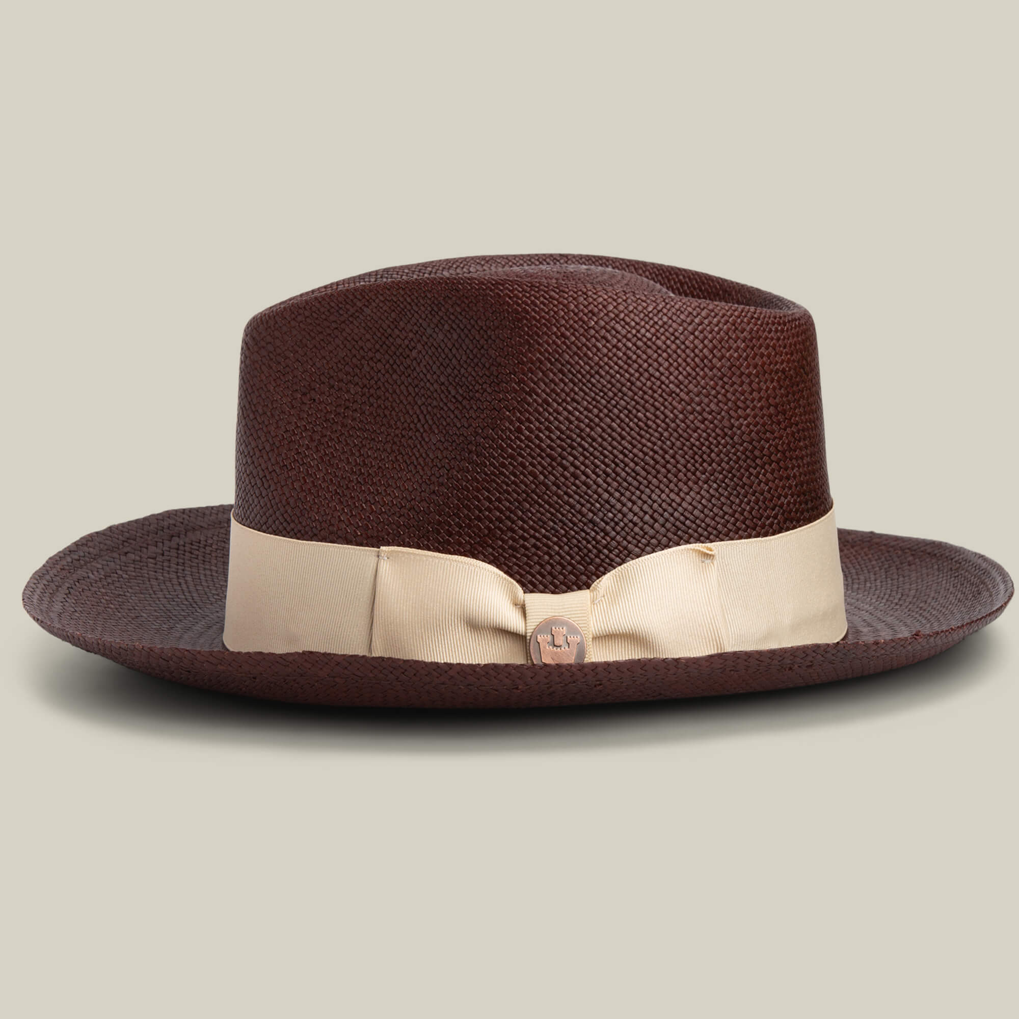 The Goorin Bros. John Sr. is a brown toquilla teardrop fedora with a wide cream ribbon band and small round side pin, offering 50 UPF sun protection, shown against a plain light background.