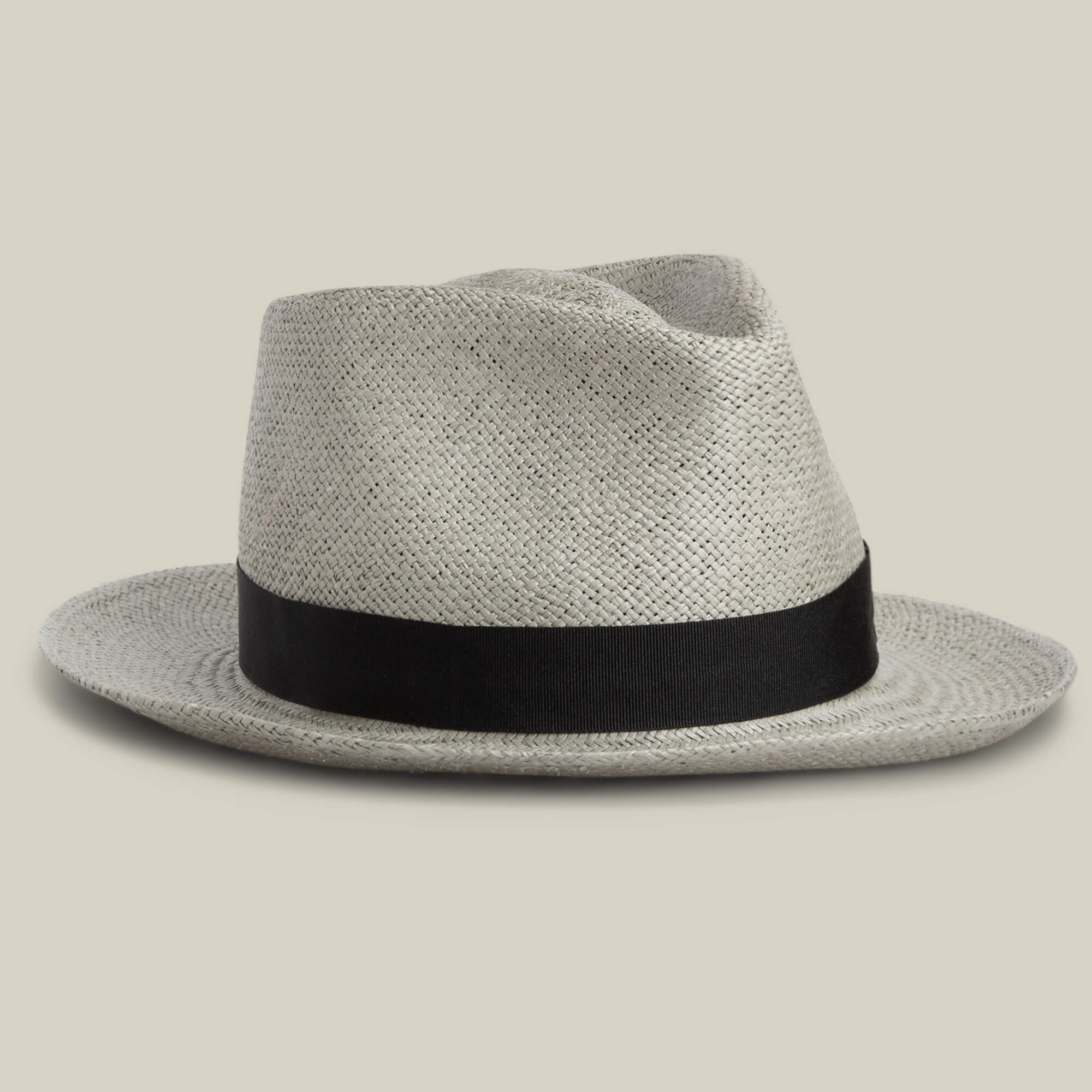 The John Sr. fedora by Goorin Bros. is a light-colored toquilla teardrop hat with a black band and 50 UPF sun protection, shown on a plain beige background.