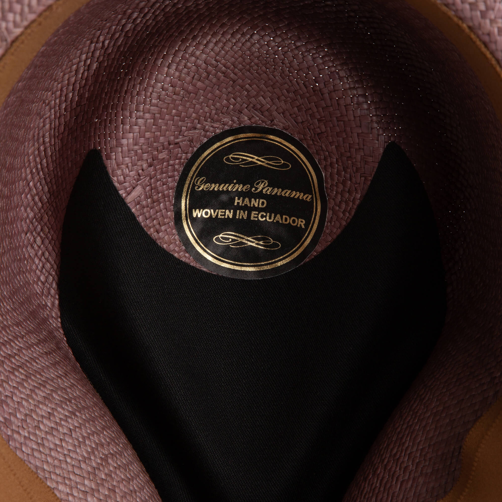 Close-up of the inside of the John Sr. teardrop fedora by Goorin Bros., showing a label reading "Genuine Panama Hand Woven in Ecuador" and part of its black lining—offers excellent sun protection with 50 UPF.