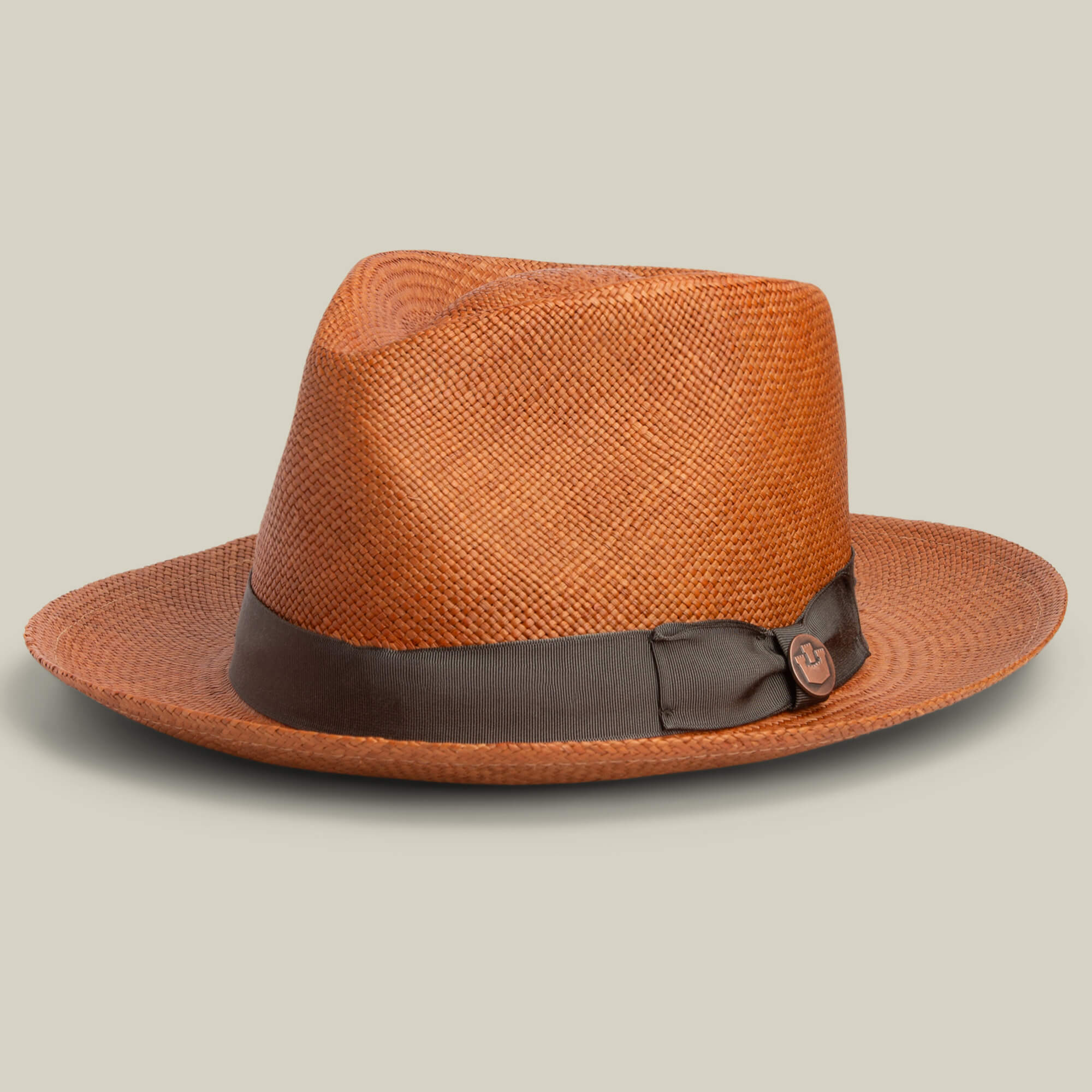 The John Sr. teardrop fedora by Goorin Bros. features brown toquilla with a dark brown ribbon band, offers 50 UPF sun protection, and is shown on a light beige background.
