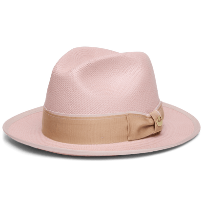The Hartman by Goorin Bros. is a light pink 100% toquilla fedora hat featuring a beige grosgrain hat band and bow, shown from the side against a white background.