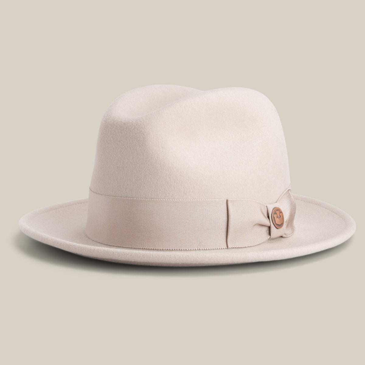 A BISCUIT-colored American-made fedora hat by Goorin Bros., called Dean the Butcher, featuring a matching ribbon band with a decorative button, set against a plain light background.