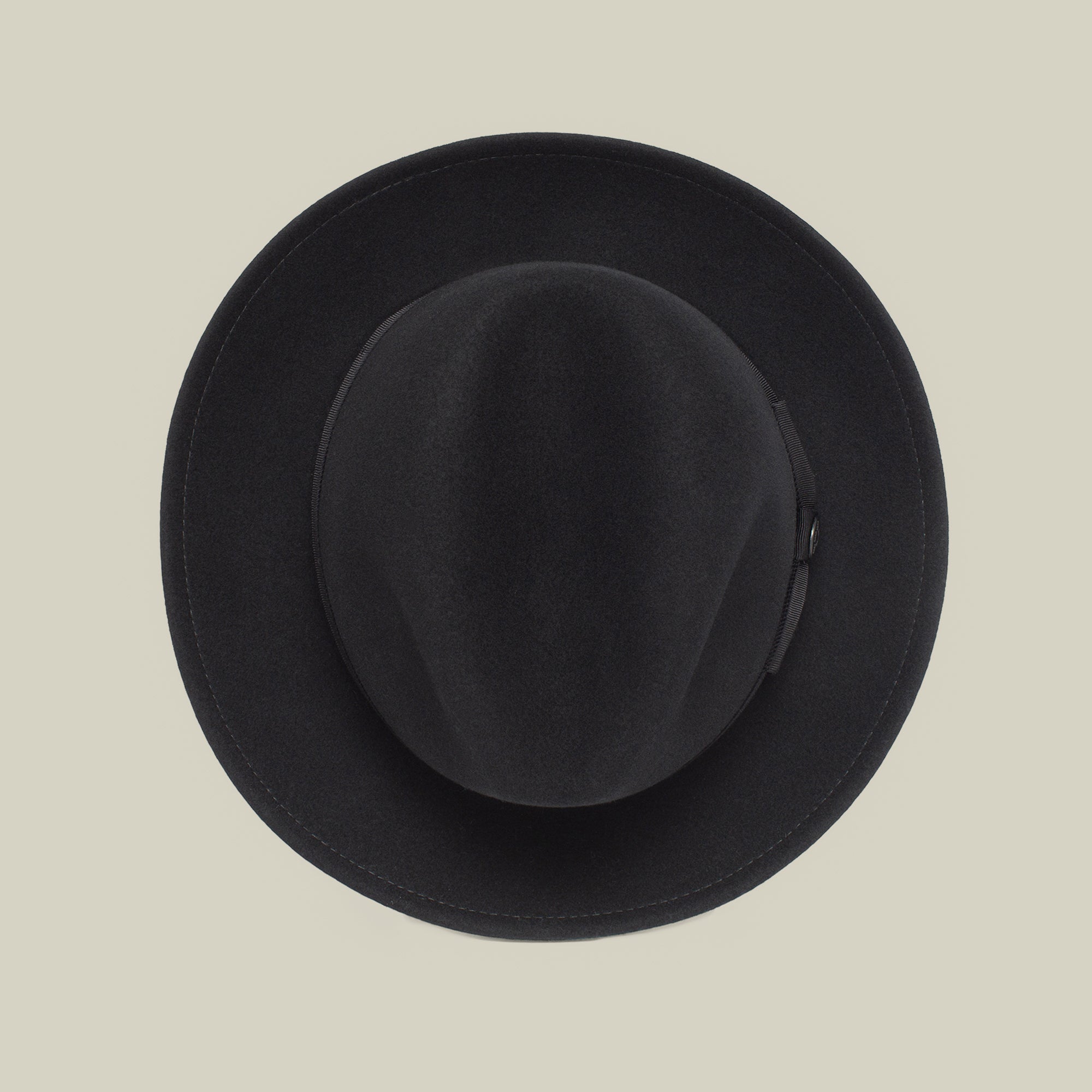 Dean the Butcher by Goorin Bros. is a black bowler hat with a grosgrain band, shown from above on a light beige background—a timeless all-season statement piece.