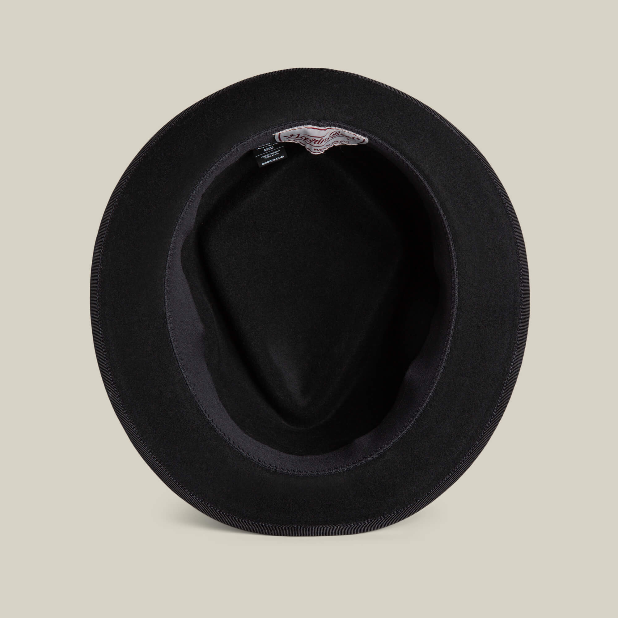 A black felt Slick Carter hat by Goorin Bros. seen from above, highlighting its interior lining and a discreet label near the inner brim—showcasing classic short-brim wool style.