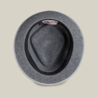 Top view of the Slick Carter gray wool short brim hat by Goorin Bros., featuring a black inner band and a fabric brand label sewn inside for effortless style.