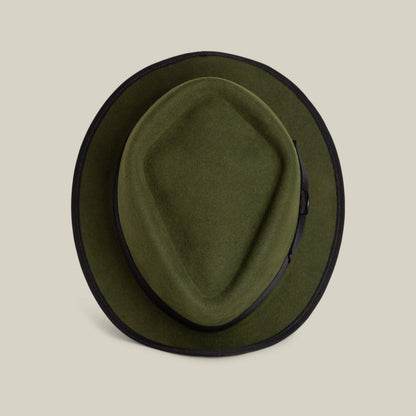The Goorin Bros. Slick Carter is a green wool felt hat with a black band and trim, short brim style, shown from above on a beige background for effortless style.