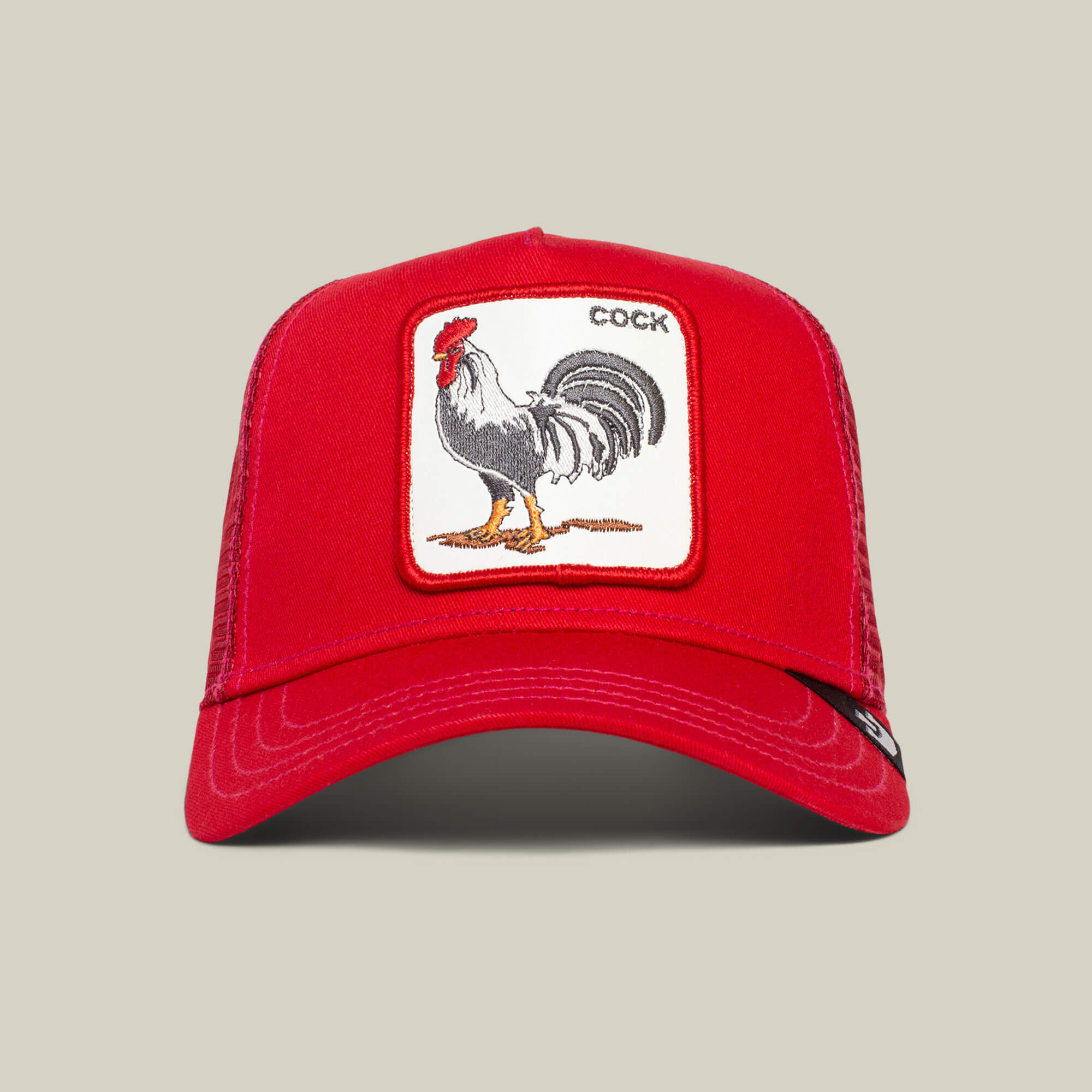 The Farm's "The Cock" is a red baseball cap with an embroidered rooster patch and the word COCK on the front.