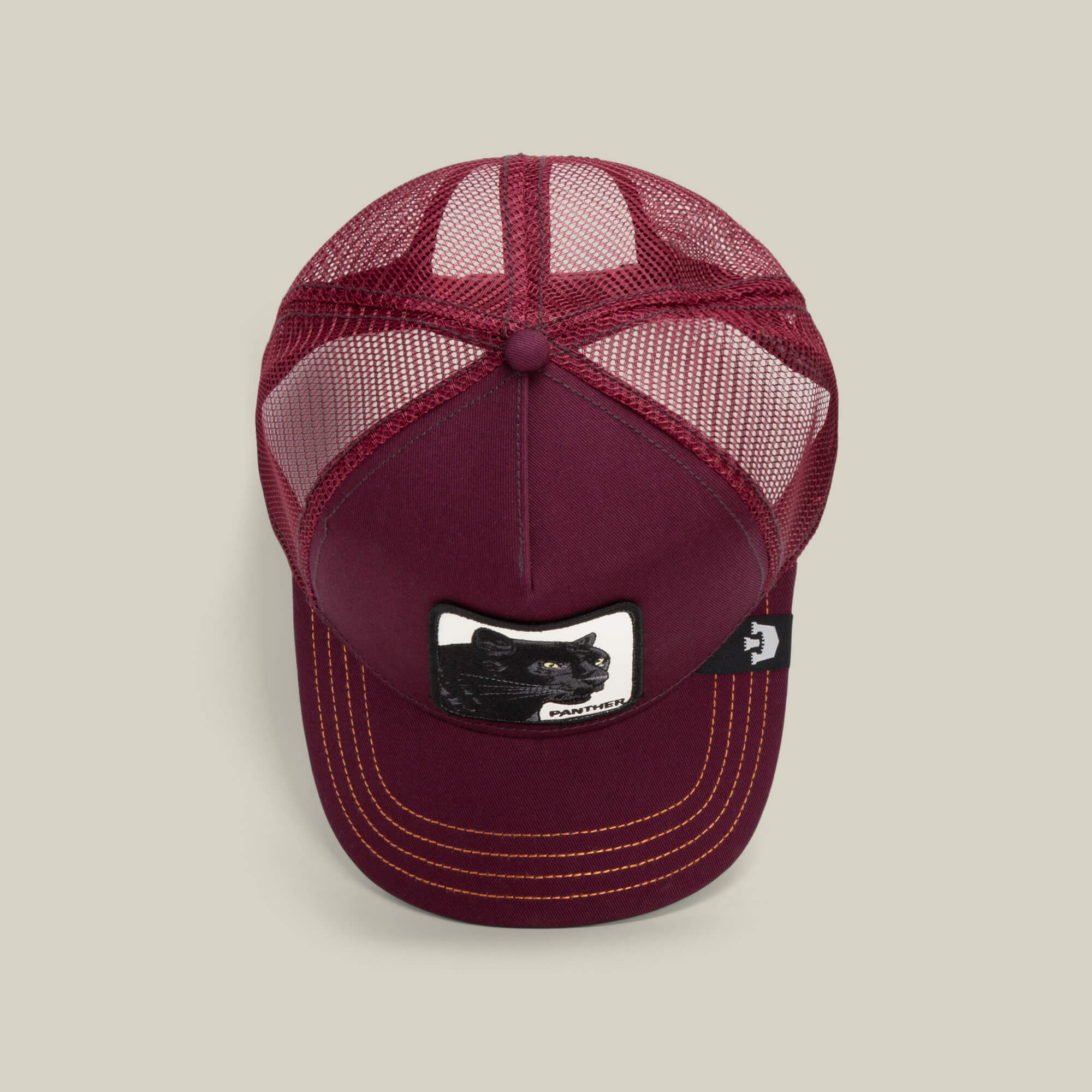 The Panther by Goorin Bros. is a maroon mesh trucker baseball hat with a black panther patch on the front, yellow stitching on the bill, and a small black side tag.