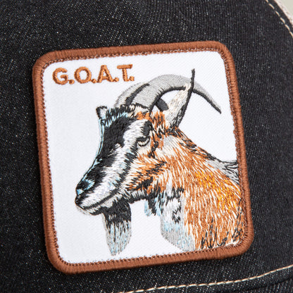 A rectangular denim patch on The Farm’s The GOAT hat features an embroidered goat and the text G.O.A.T. in brown, celebrating the Greatest Of All Time style.