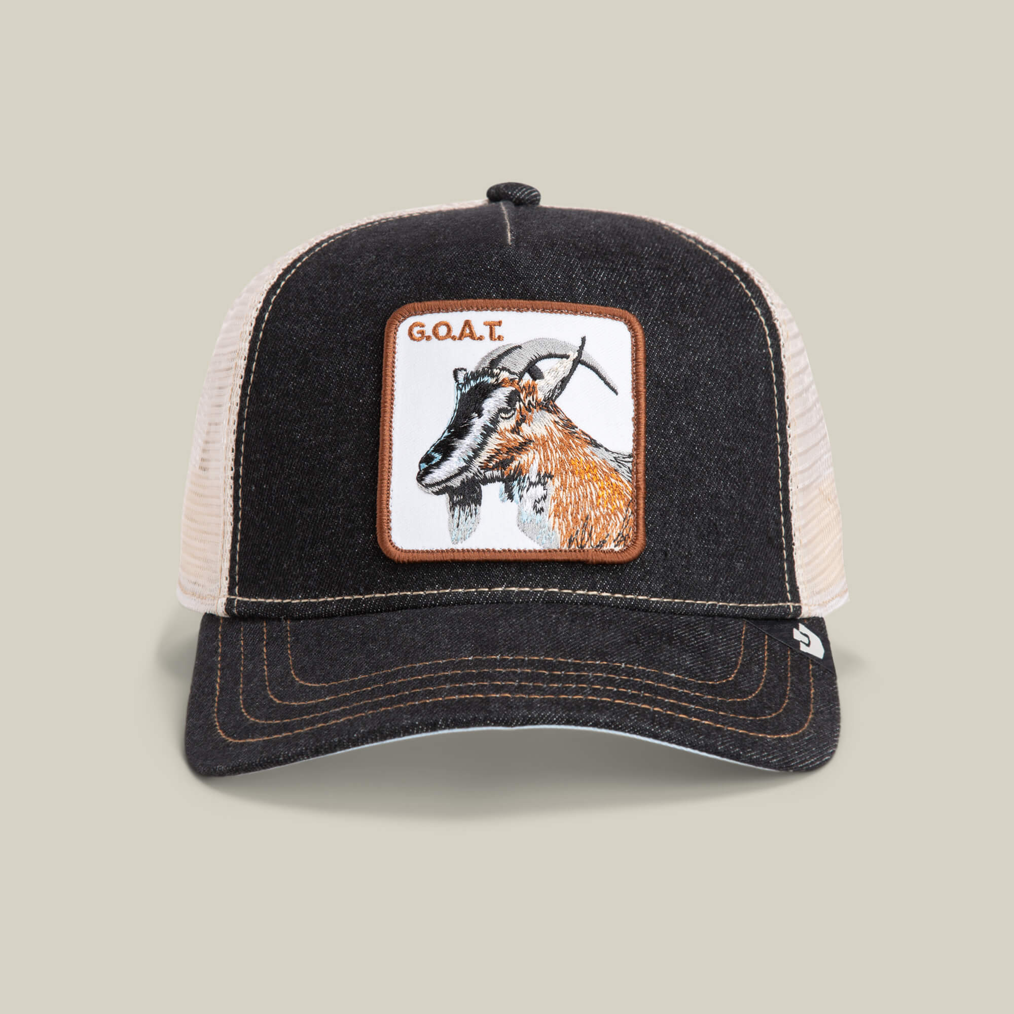 The Farm’s “The GOAT” is a black and beige mesh trucker hat with a front patch featuring a goat illustration and G.O.A.T. text—the perfect hat to show off your Greatest Of All Time style.