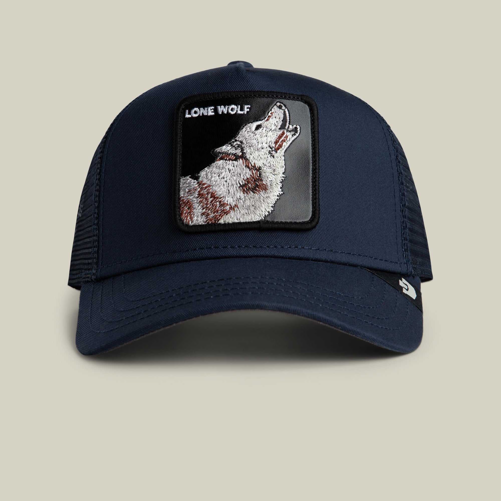 The Farm’s The Lone Wolf navy blue trucker hat features a mesh back and a front patch with an embroidered howling wolf and “LONE WOLF”—ideal for the independent spirit.