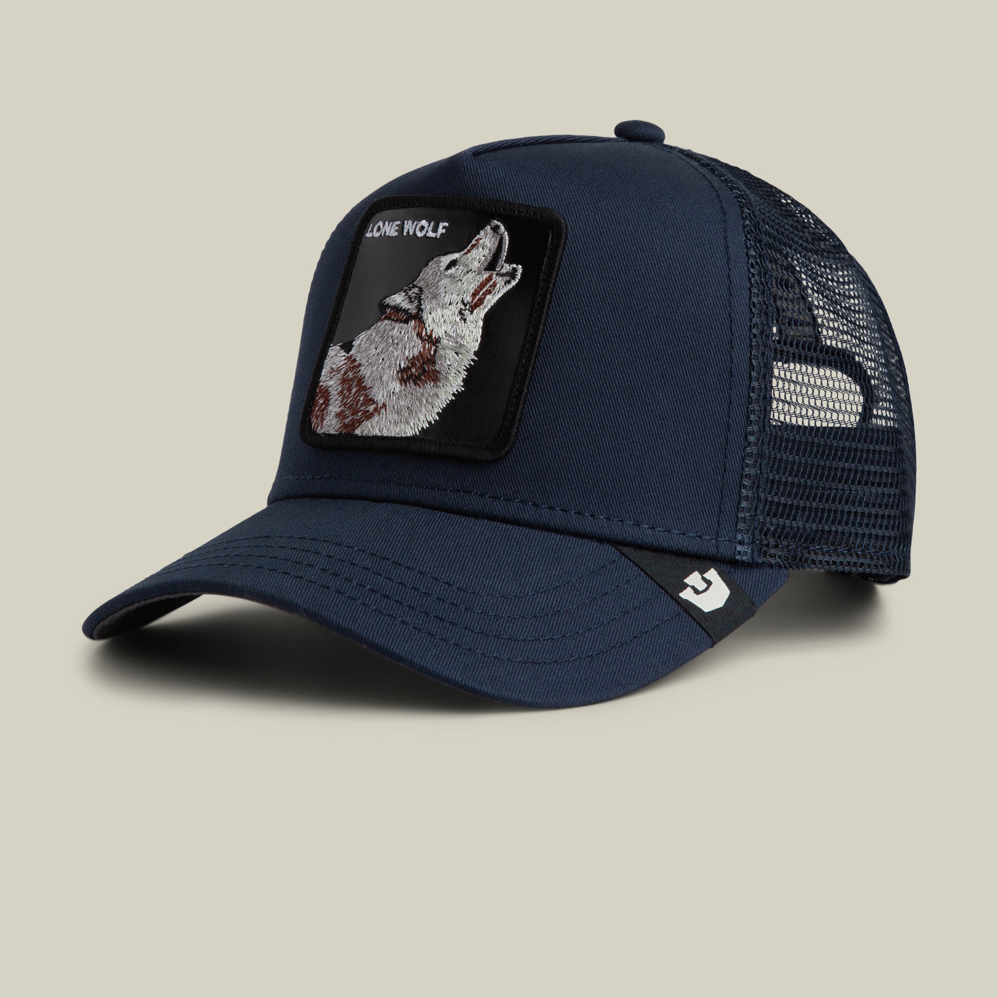 The Farm's "The Lone Wolf" navy blue trucker hat features a mesh back and a front patch with a howling wolf and "LONE WOLF"—ideal for independent spirits.