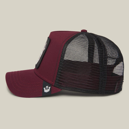The Farm’s “The Lone Wolf” is a maroon and black trucker hat with mesh back and front patch, shown in side profile—perfect for the independent spirit.