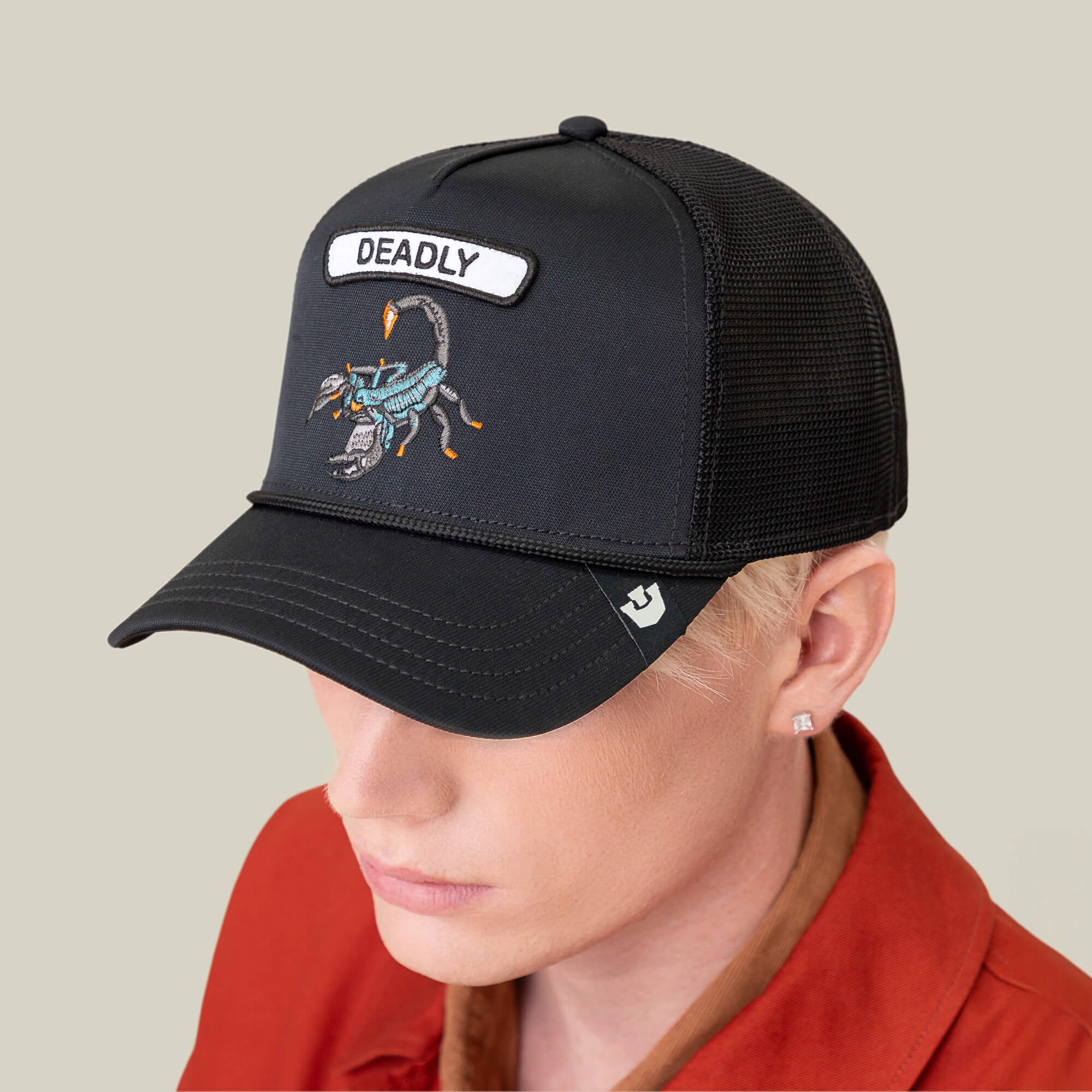 Someone wearing the Goorin Bros. GB2 Deadly Scorp cap, a matte black baseball hat with a mesh back and a bold front scorpion patch labeled "DEADLY.
