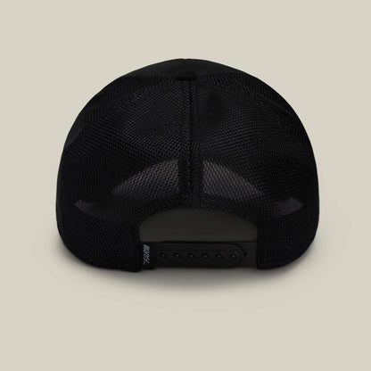 The Suede Spider by Goorin Bros. is a black mesh trucker hat shown from the back with an adjustable snapback closure against a beige background—a funny dad gift.