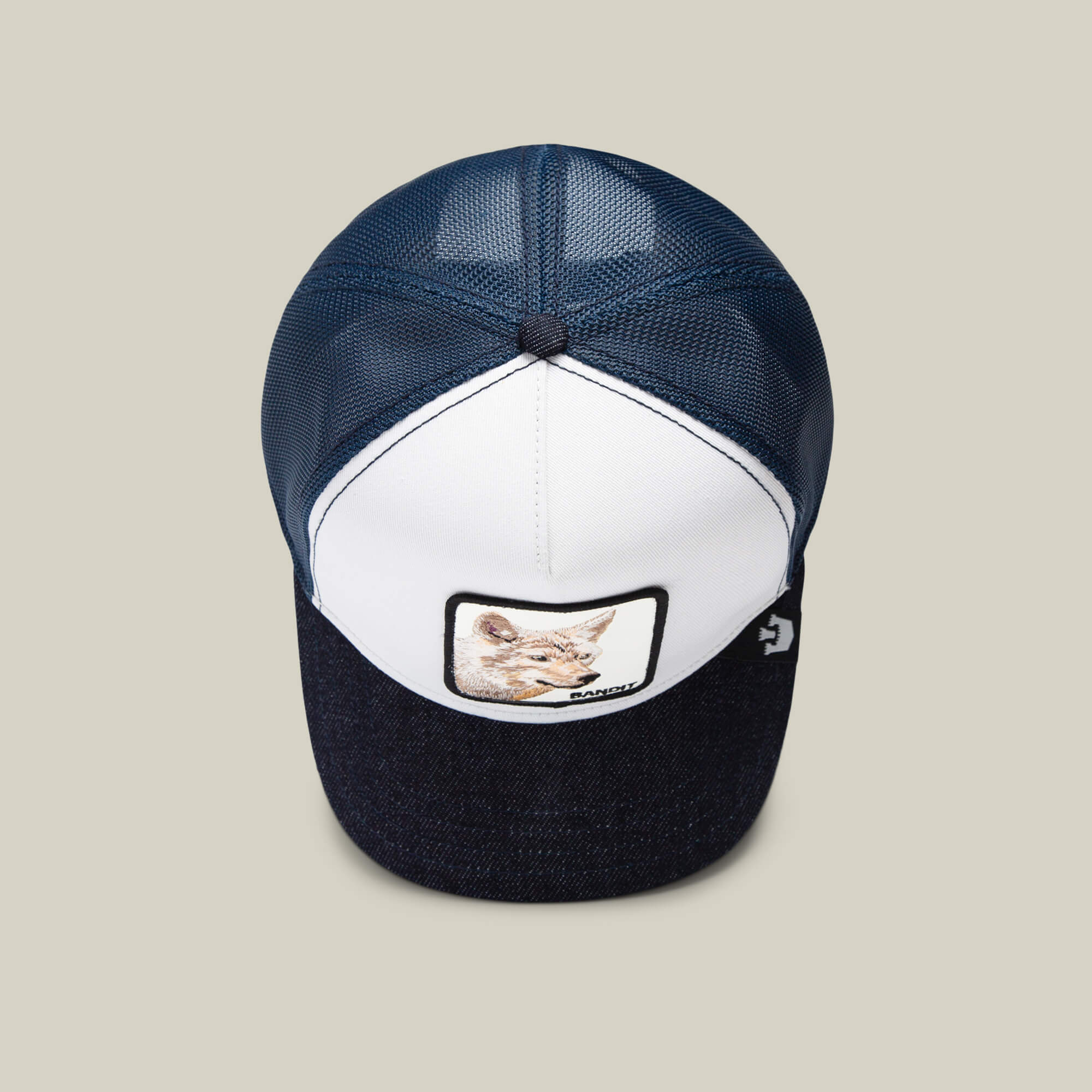 The Farm’s "The Bandit Coyote" is a blue and white trucker hat featuring a front patch with an illustrated coyote face—perfect for those with a wild spirit.