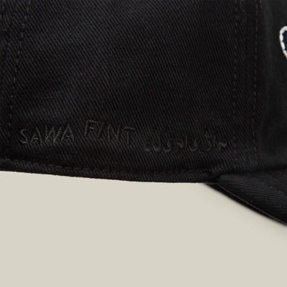 Close-up of a black papa cap from Goorin Bros.' Fine Headwear collection, featuring "Sawa Tant" and Arabic text embroidered in black thread on the side—showcasing stylish design.