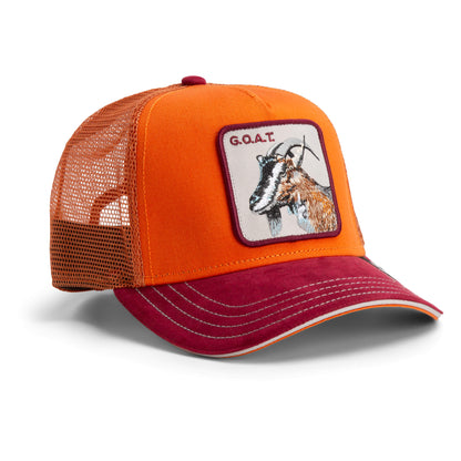 Orange and red mesh-back trucker cap from The Farm, with a front patch showing a goat and “Greatest Grazer” plus “G.O.A.T.” embroidered above. All sales final.