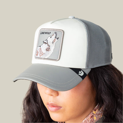A person wears the Goorin Bros. LFG Lone Wolf grey and white trucker hat with a wolf patch, styled with courtside sneakers for a perfect tunnel fit look.