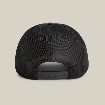 Back view of the Means Yes hat by Goorin Bros., this black mesh trucker features an adjustable snapback closure, displayed on a plain beige background—a distinct fashion accessory.