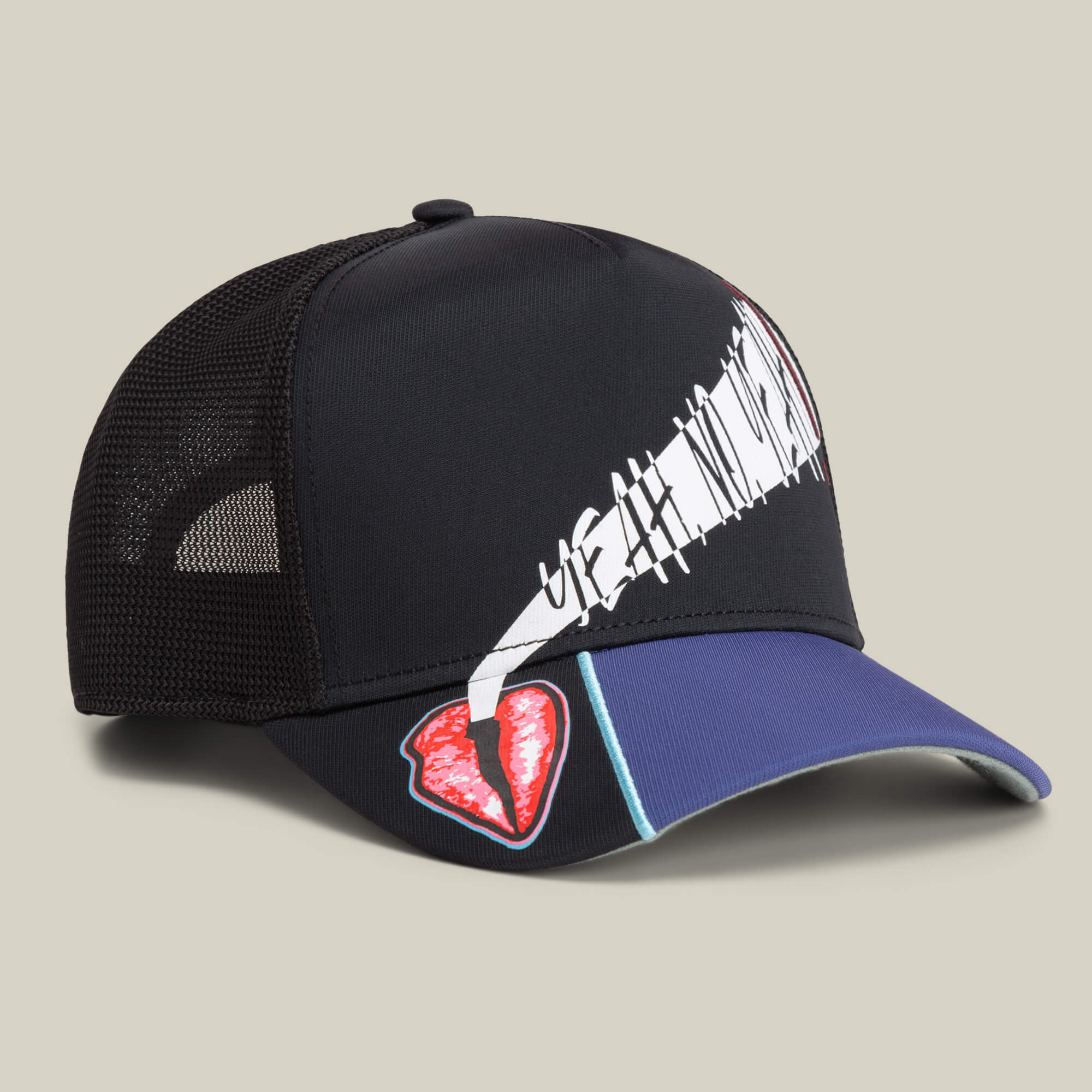 The Means Yes hat by Goorin Bros. features black mesh, a white abstract graphic on the front, and a red broken heart patch on the blue brim—a bold accessory shown against a neutral background.