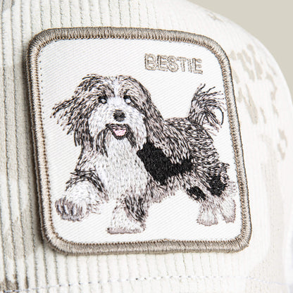 A close-up of the Bestie Camo patch by Goorin Bros., featuring soft corduroy and an embroidered fluffy dog with "BESTIE" above it—ideal for any shaggy pup patch lover.