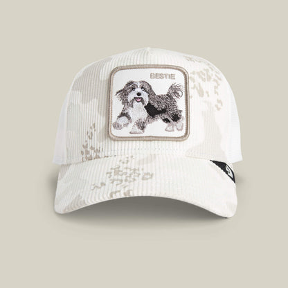 The Goorin Bros. Bestie Camo is an off-white snow camo corduroy baseball cap with a front patch that has an embroidered black and white dog and the word "BESTIE.