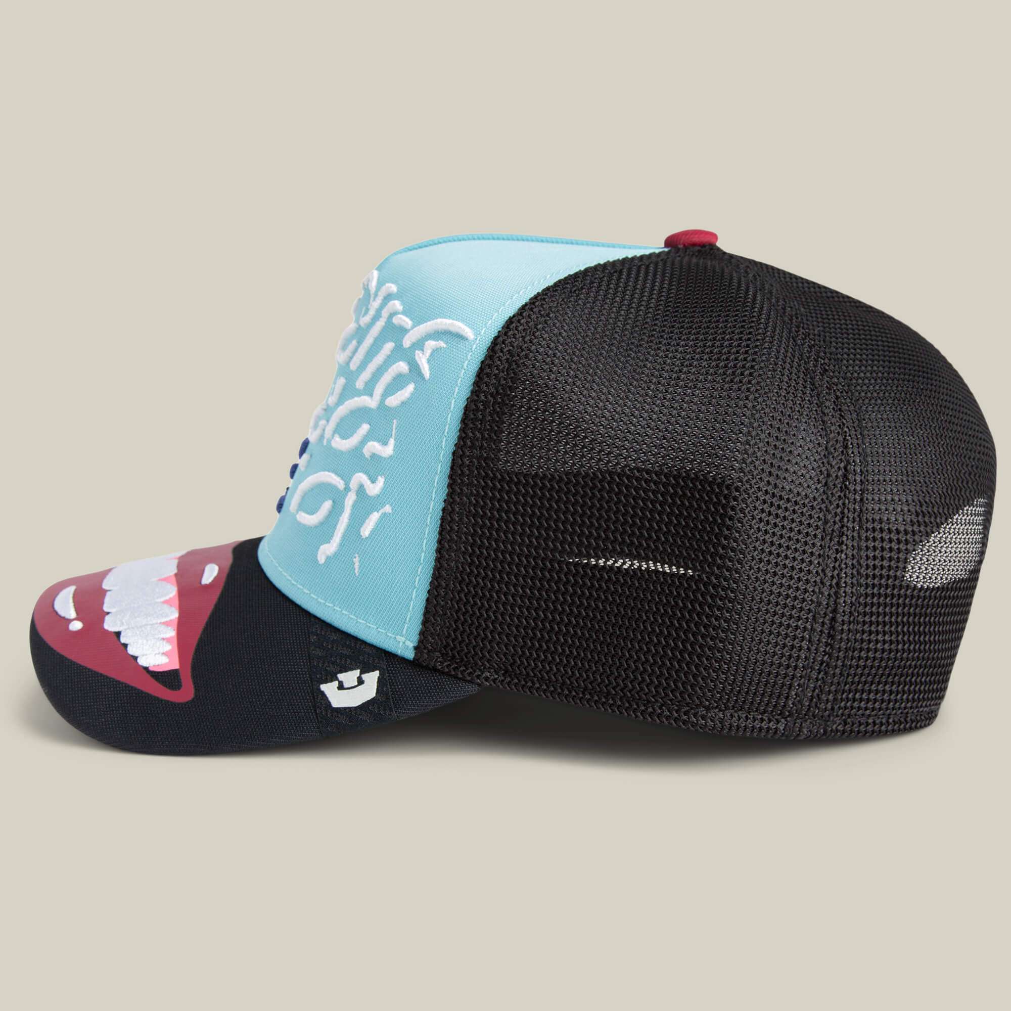 The Means Understood by Goorin is a mesh-back trucker hat with a blue front, black brim, white teeth graphic, and bold white side text—designed for those who wear confidence on top.