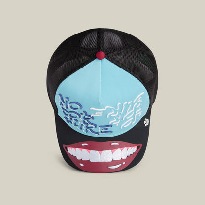 The Goorin "Means Understood" trucker hat in black and light blue features embroidered text, a brain graphic on the crown, and a bold cartoon mouth with teeth on the brim—designed to boost your confidence.