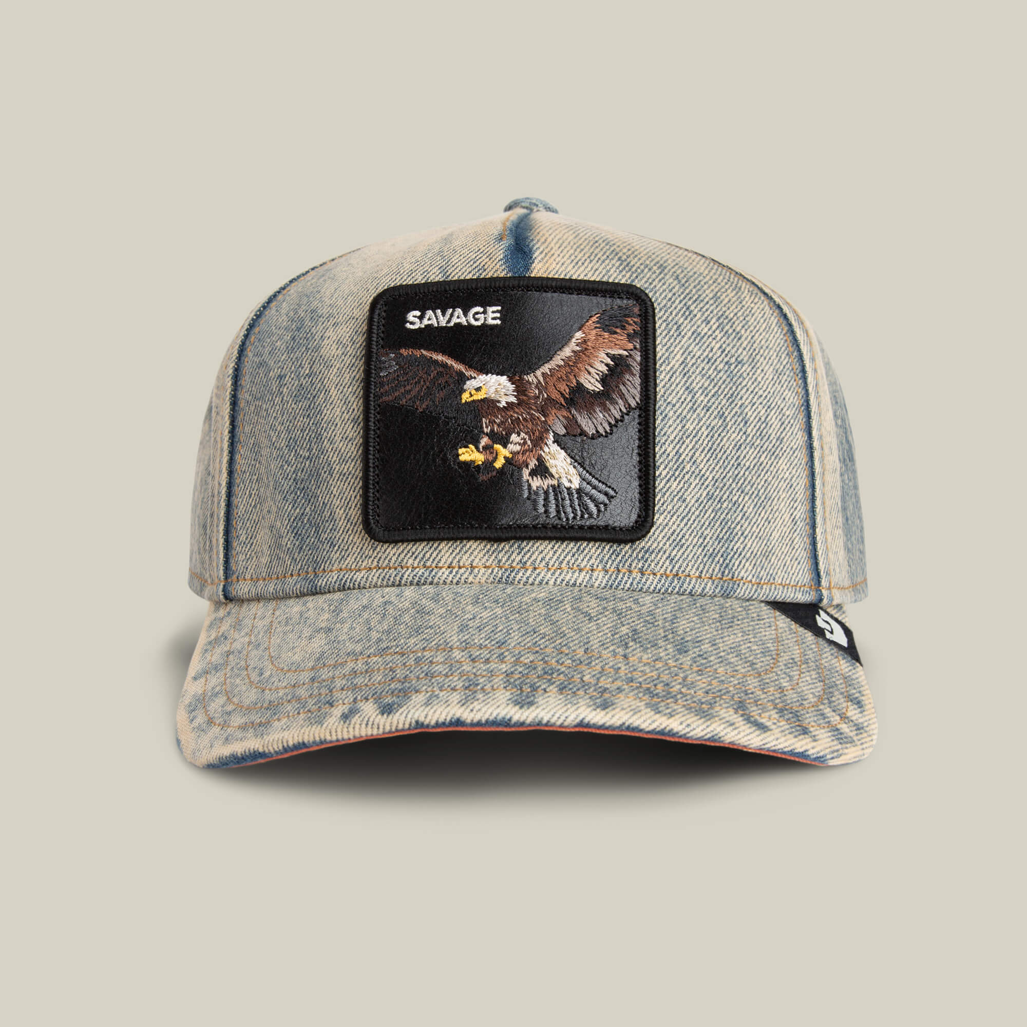 The Goorin Bros. Frequent Flyer is a light denim cap with a front patch showing an embroidered eagle and the word SAVAGE above it.