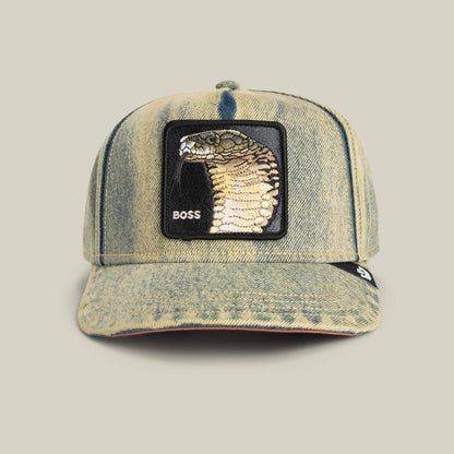 The Goorin Bros. Pit Boss is a denim hat with a striking cobra patch and "BOSS" embroidery on the front, delivering an edgy statement to any outfit.