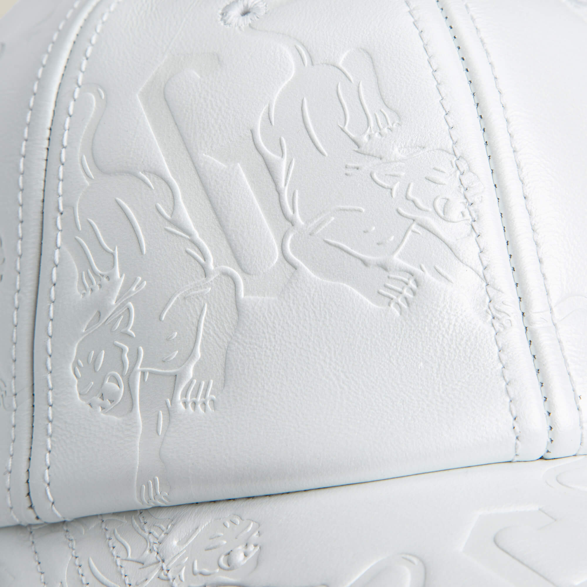 Close-up of the white leather front panel of Goorin Bros.' classic-fit "Put a Panther On It" hat, featuring embossed panther and geometric designs.