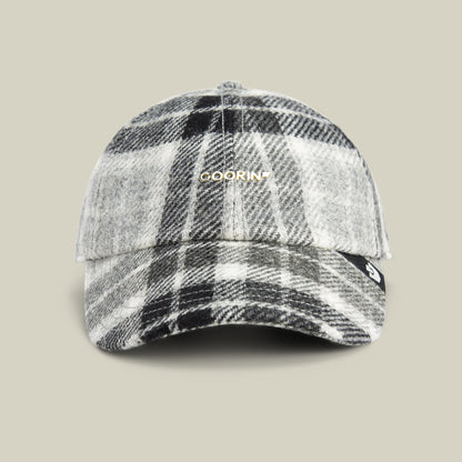 The Goorin Bros. Bespoke Wordmark baseball cap in GLOSS, featuring a standout gold wordmark, is showcased against a plain beige background.