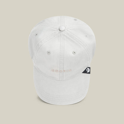 The Papa Cap Italiano by Goorin Bros. features classic white fabric, visible stitching, a small embroidered GOORIN logo on the front, and a black side tag with a white graphic—timeless style in every detail.