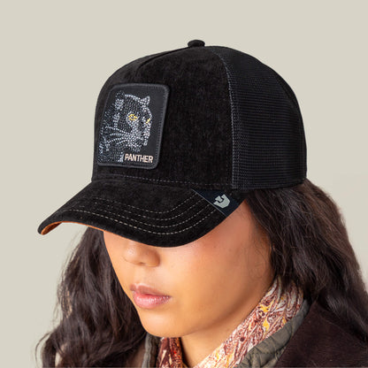 A person wearing the Goorin Bros. Iced Panther black mesh baseball cap with an embroidered luxury panther patch on the front, their face partially hidden by the cap.