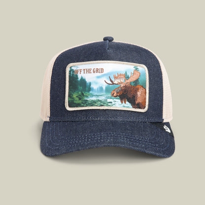 The Goorin Bros. Staycation hat in GRAY DENIM features a mesh design, a denim crown, a moose patch with a forest river scene, and the text OFF THE GRID.