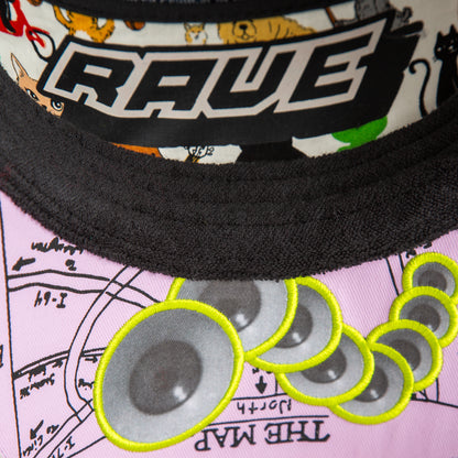 Close-up of Goorin Bros.’ Trance hat, featuring RAVE lettering, illustrated animals, and embroidered speakers on pink fabric labeled THE MAP—a standout festival accessory for fans living life at 128 BPM.
