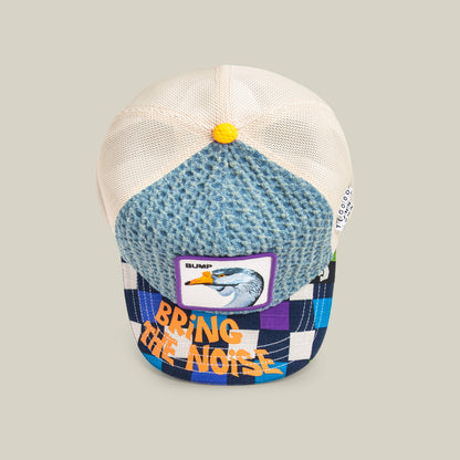 The “Acid House” trucker hat by Goorin Bros. features a blue textured front, mesh back, a bird patch with “BUMP,” and a checkered brim with “BRING THE NOISE”—ideal for Acid House fans heading to their next laser dome party.