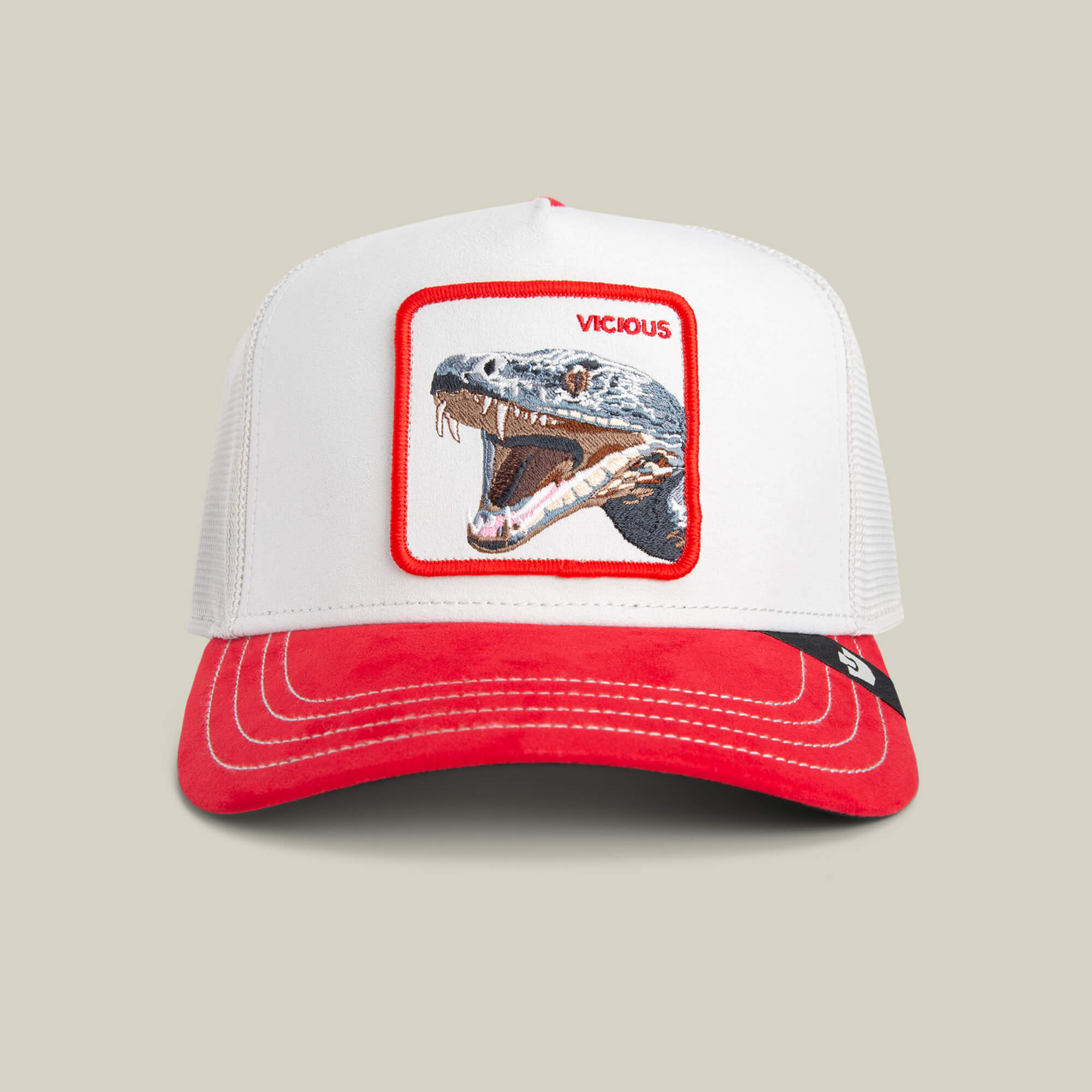 The Goorin Bros. Suede Snake is a white and red premium trucker hat with a smooth, comfortable finish, featuring a patch of an open-mouthed dinosaur and the word "VICIOUS" above it.
