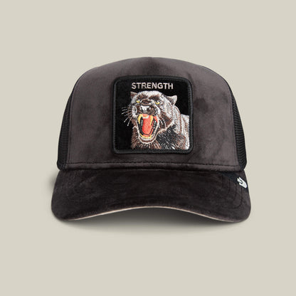 The Goorin Bros. Velour Panther hat in VOID features a black velour finish and a patch with a roaring panther and "STRENGTH" embroidered above, showcased against a beige background.