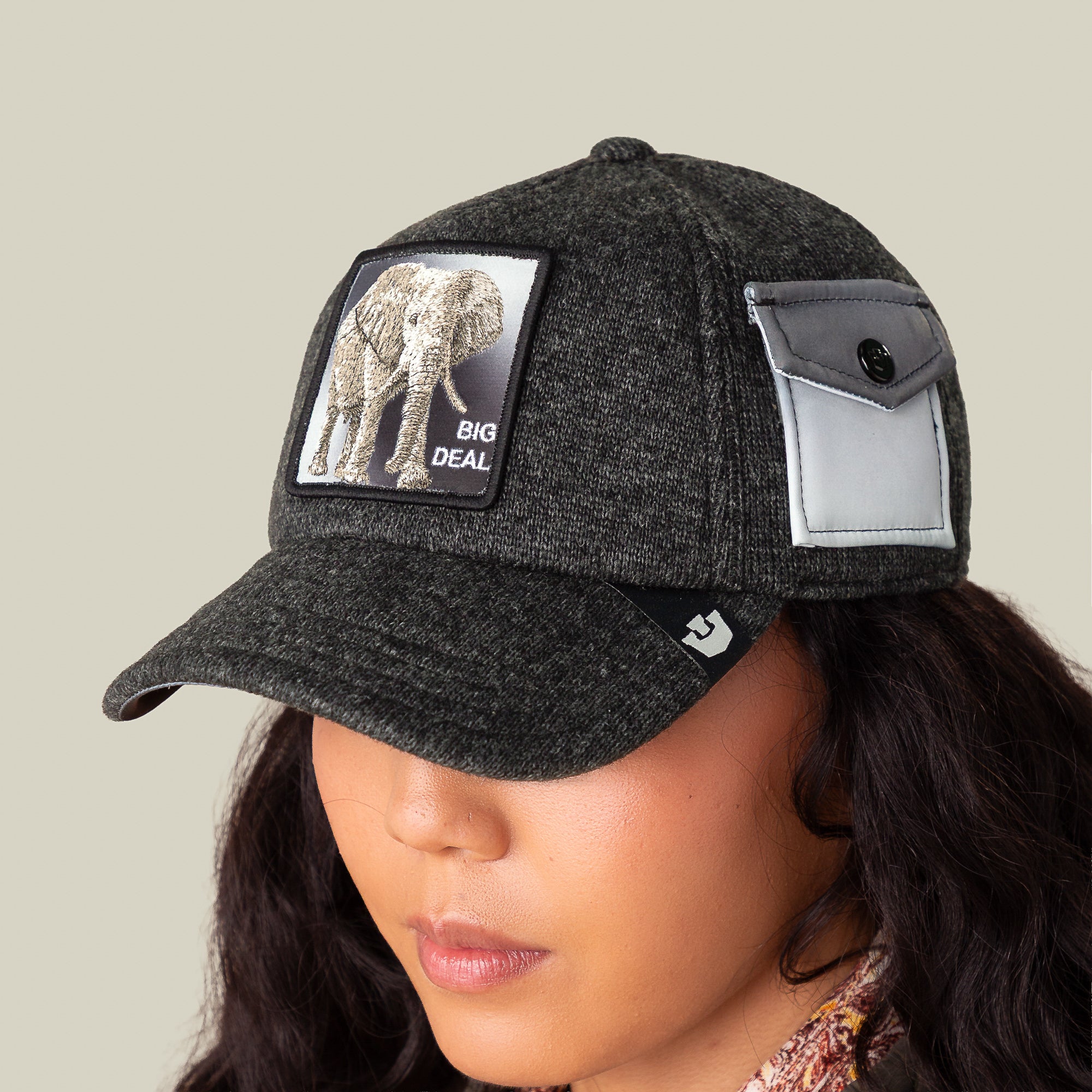 Wearing the Goorin Bros. "Kind of" cap: dark gray, elephant patch with "BIG DEAL" text, side pocket with button, all crafted from epic sweater material for ultimate comfort.