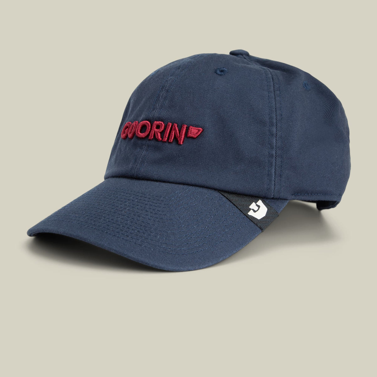 The Goorin Bros. Papa Core is a navy blue dad hat with red embroidered text on the front, displayed against a neutral beige background in a studio product shot.