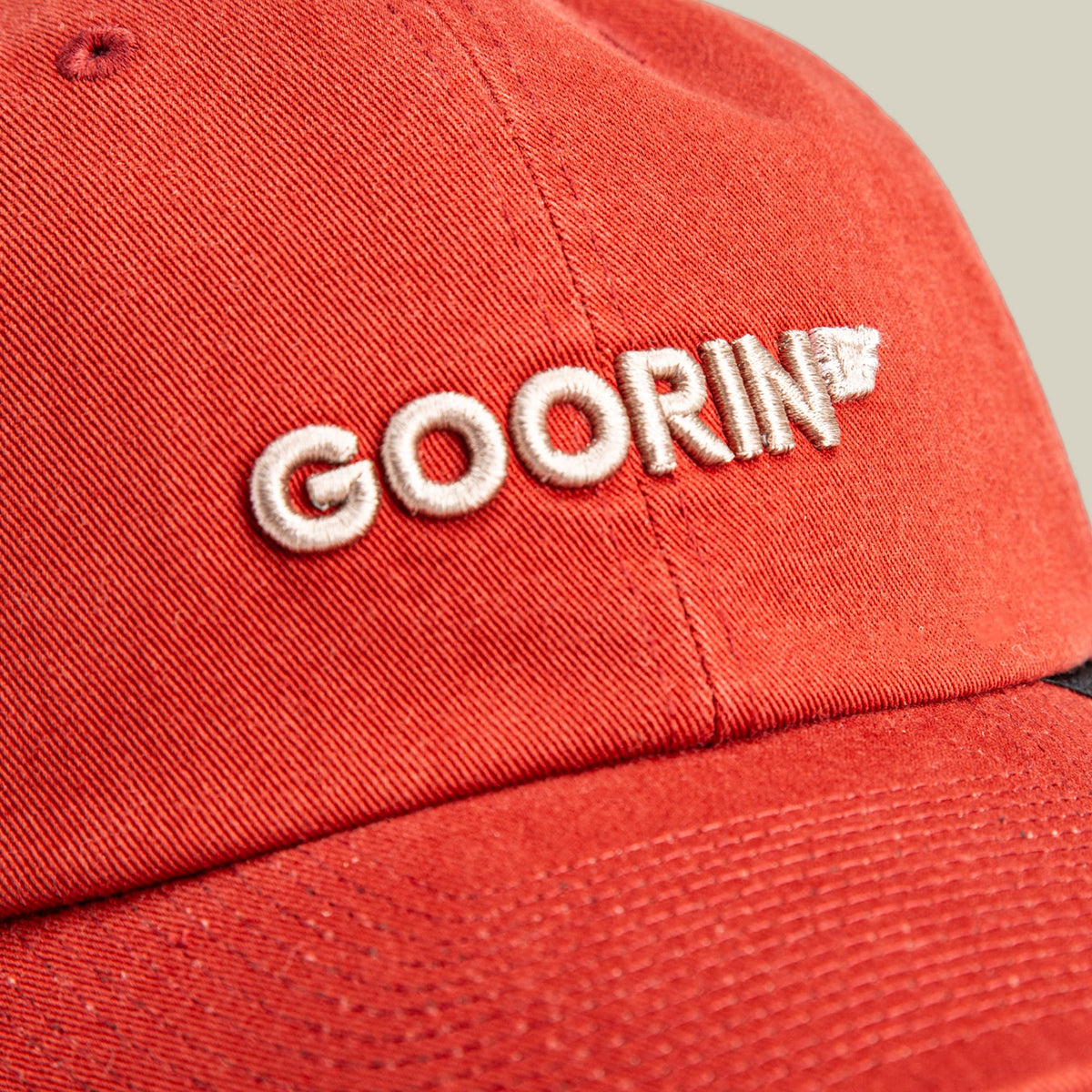 The Goorin Bros. Papa Core red baseball cap features white embroidered logo text on the front and a textured cotton construction, shown in a close-up studio product shot.