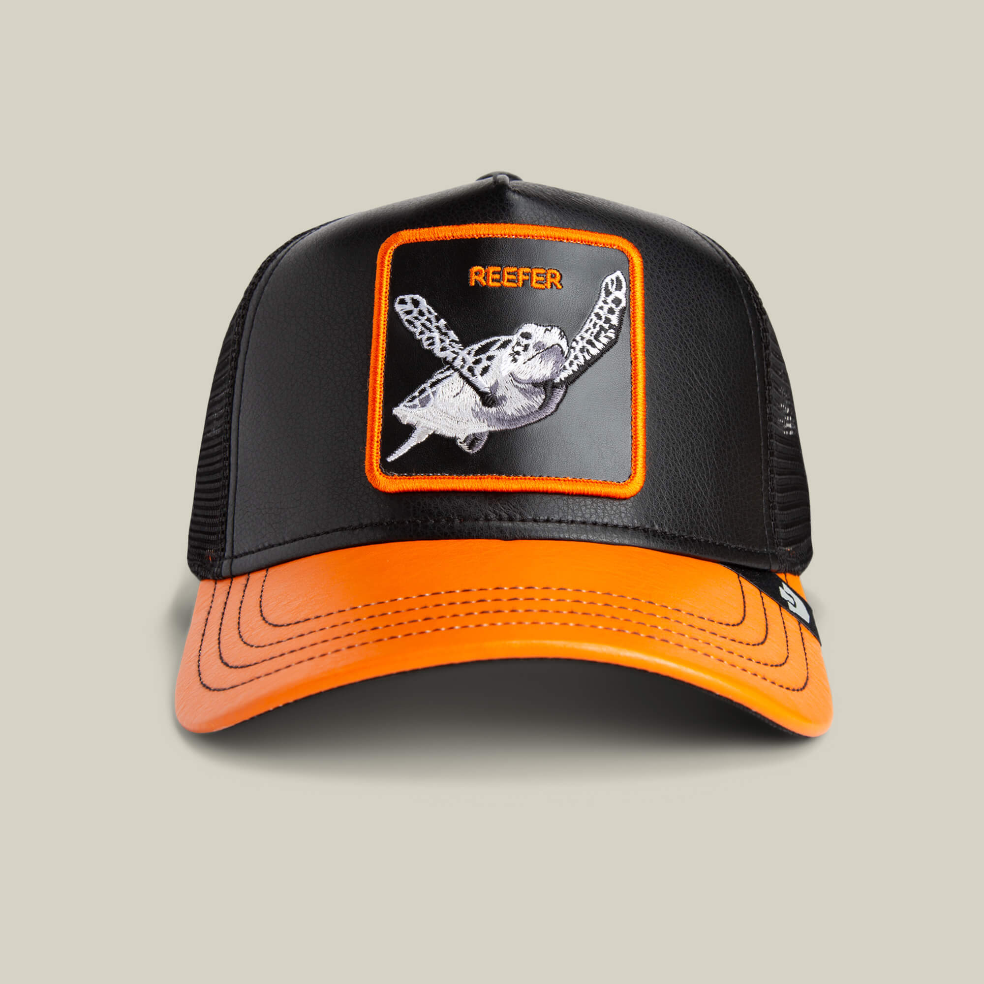 Black and orange Goorin Bros. Courtside Reefer trucker hat, featuring a sea turtle patch and "REEFER" text—ideal for matching with your retro high tops or VOID / BLAZE Courtside Reefer sneakers.